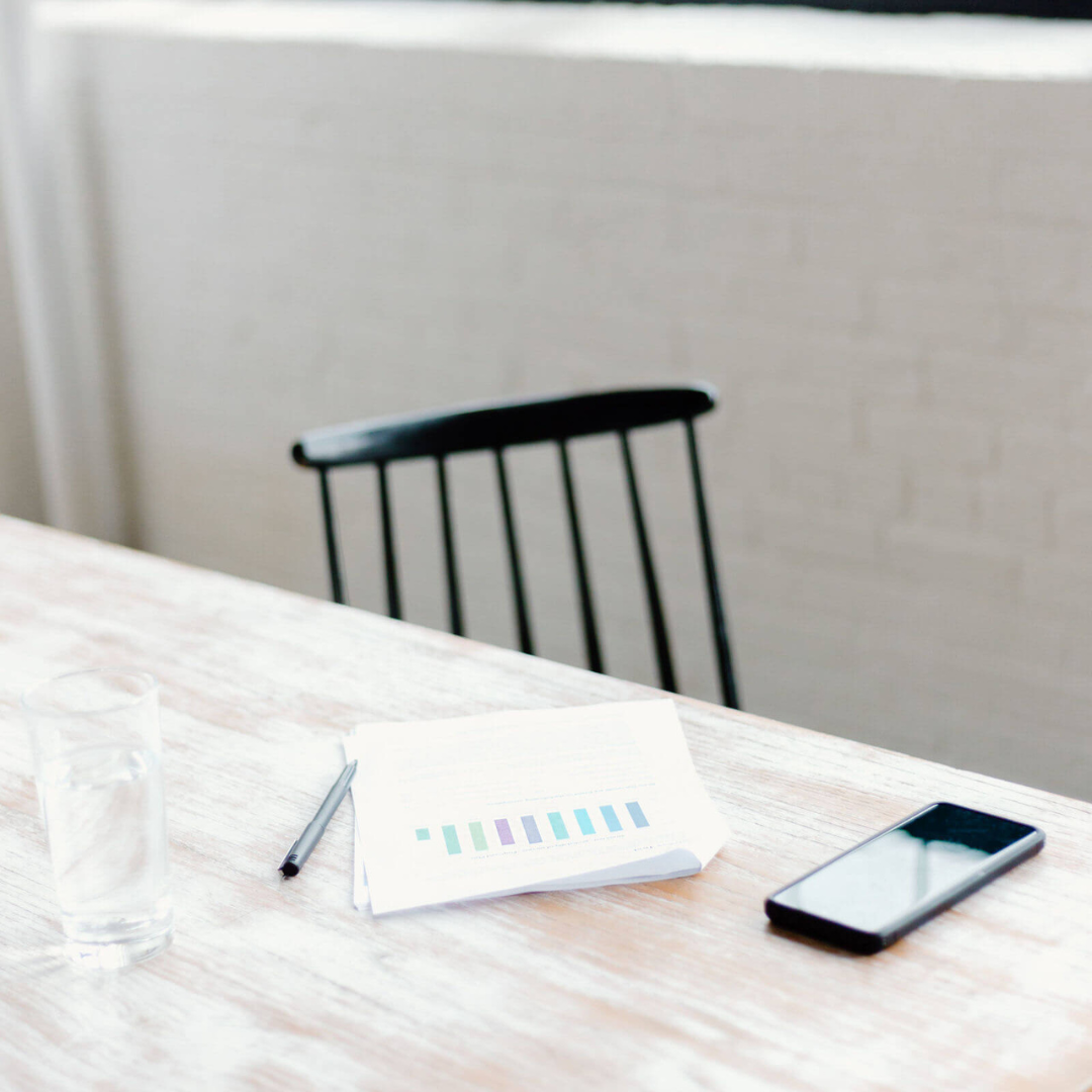 desk with papers and phone, chair in background