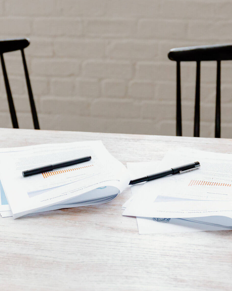 Two packets of paper with pens on a table
